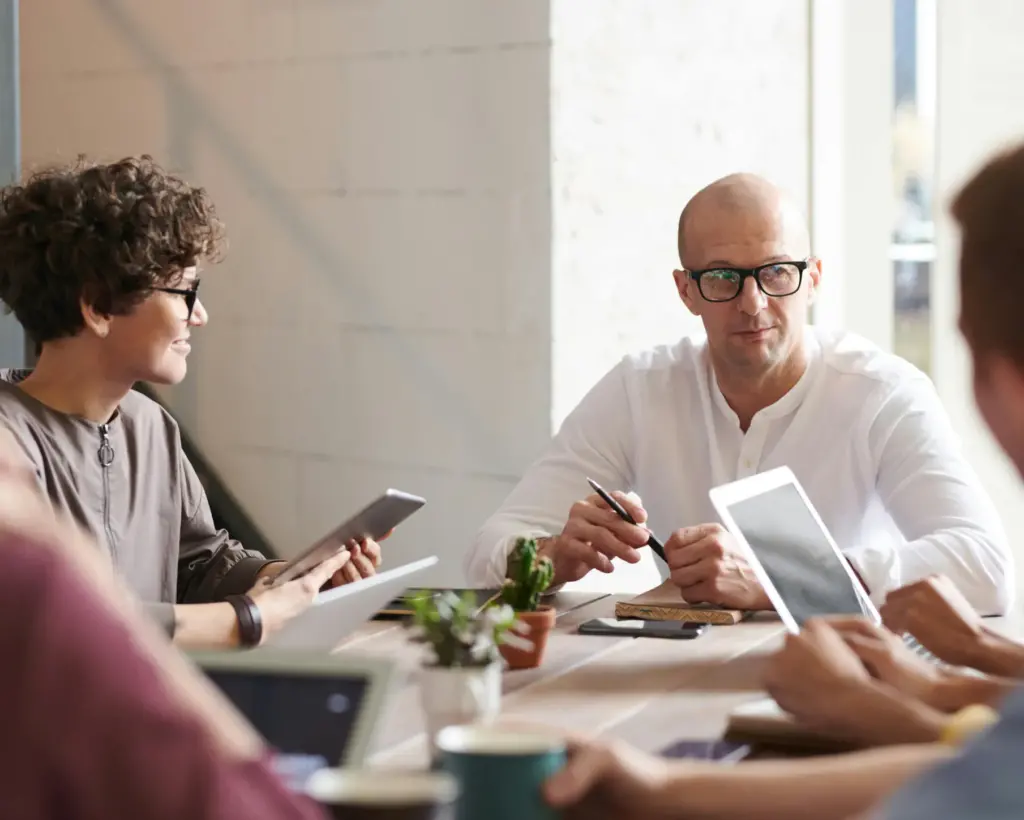 people sitting around a meeting with tablets 