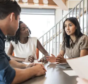 three people sitting together in a meeting